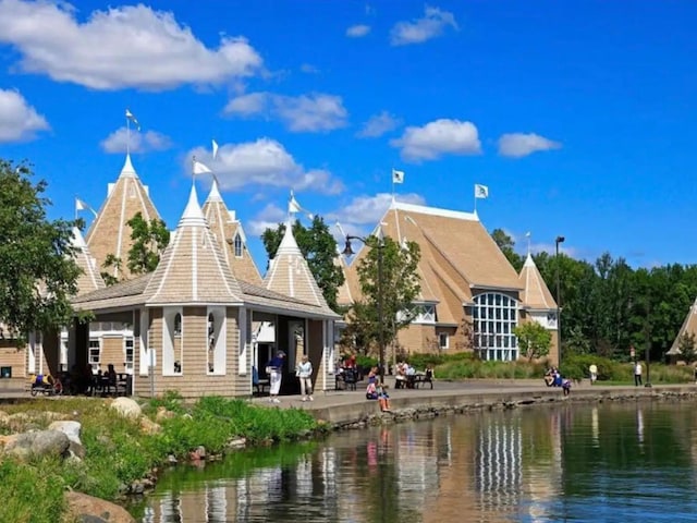 view of community with a patio area and a water view