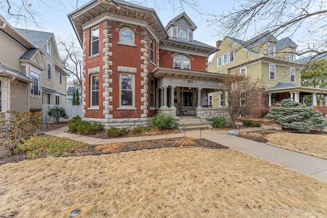 italianate-style house with brick siding and fence