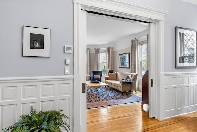 living area featuring wood finished floors and wainscoting