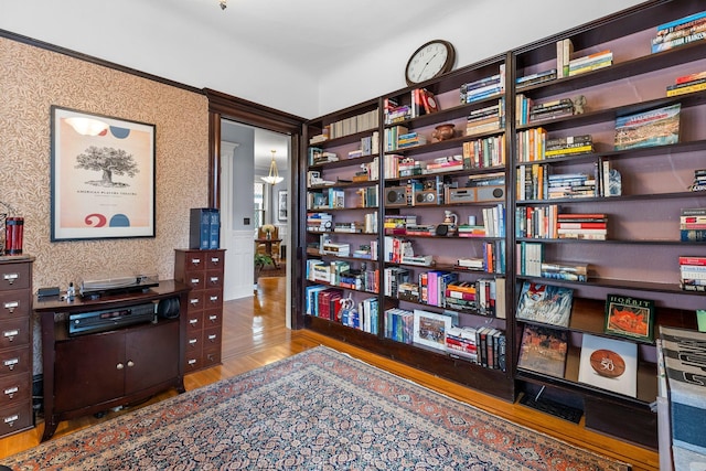 office space with wallpapered walls and wood finished floors