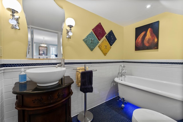 full bath featuring tile walls, a wainscoted wall, recessed lighting, a freestanding tub, and vanity