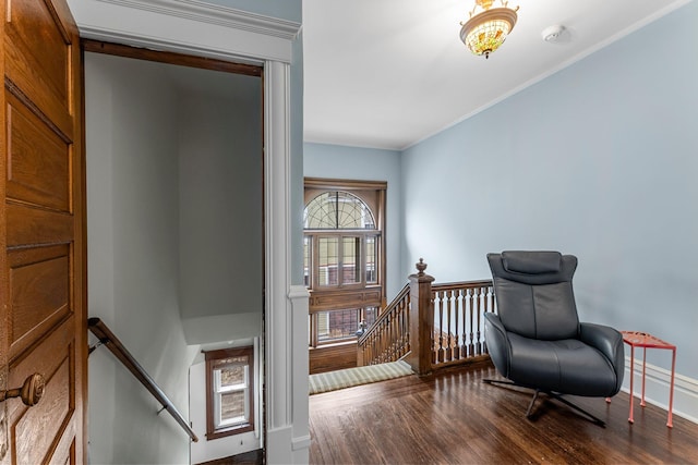 sitting room with an upstairs landing, crown molding, baseboards, and wood finished floors