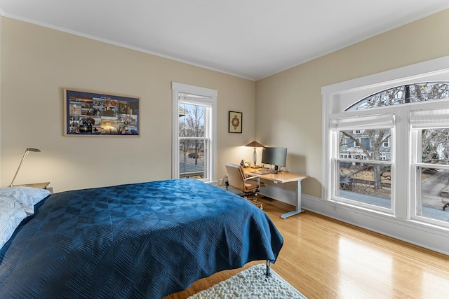 bedroom featuring wood finished floors and ornamental molding