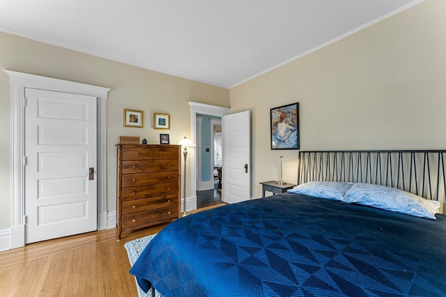 bedroom with baseboards, wood finished floors, and crown molding