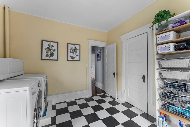 laundry area featuring crown molding, dark floors, baseboards, laundry area, and washing machine and clothes dryer