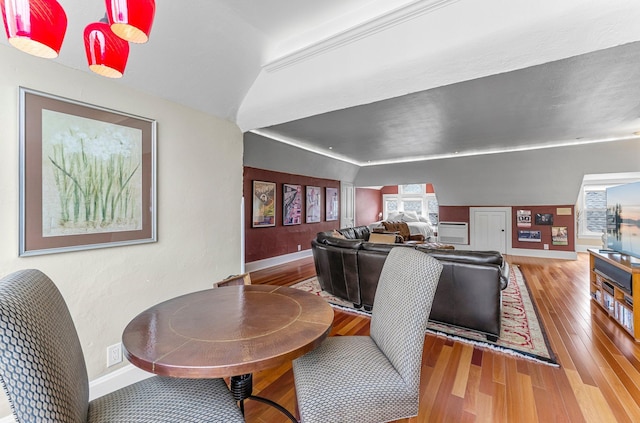 dining area with vaulted ceiling, baseboards, and wood finished floors