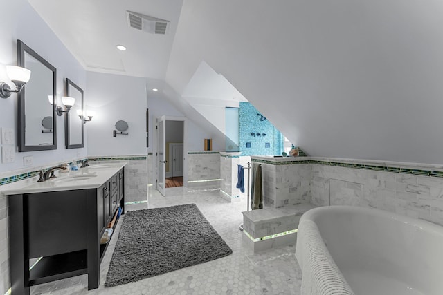 full bathroom with a tub to relax in, visible vents, a sink, vaulted ceiling, and tile walls