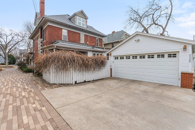 traditional style home featuring brick siding, an outdoor structure, and a garage