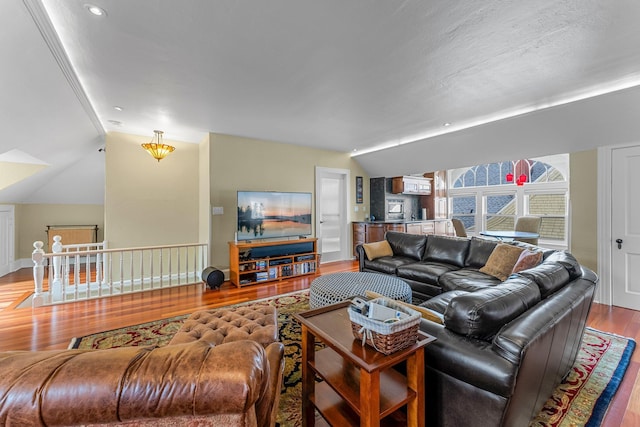 living area with recessed lighting, lofted ceiling, and wood finished floors