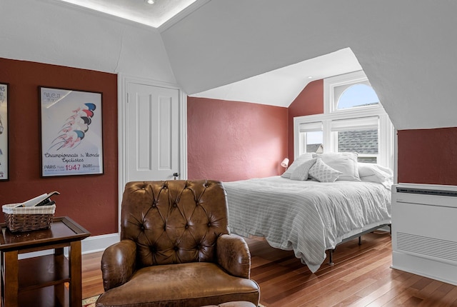 bedroom with hardwood / wood-style flooring and lofted ceiling