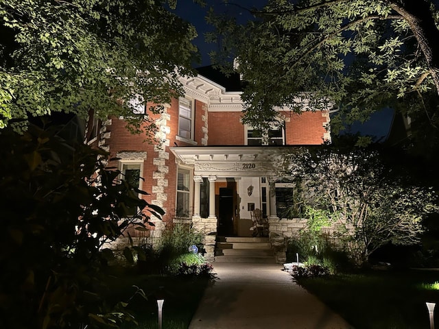 back of property featuring stone siding and brick siding