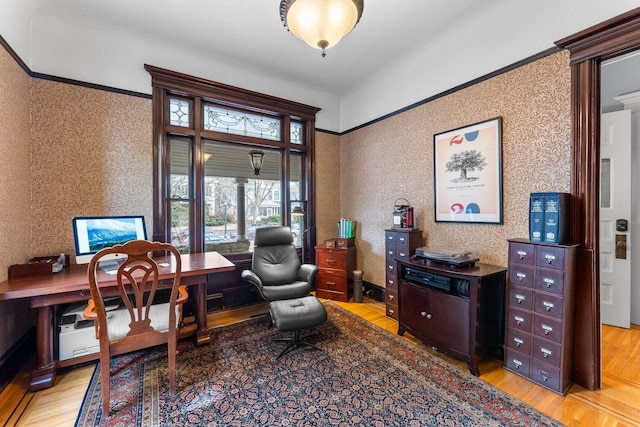 office area with light wood finished floors and wallpapered walls