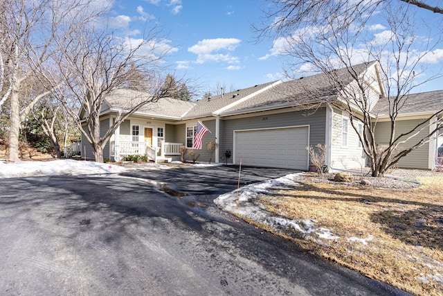 ranch-style house featuring a garage and aphalt driveway