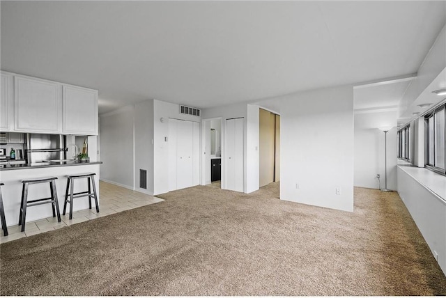 unfurnished living room with light carpet and visible vents