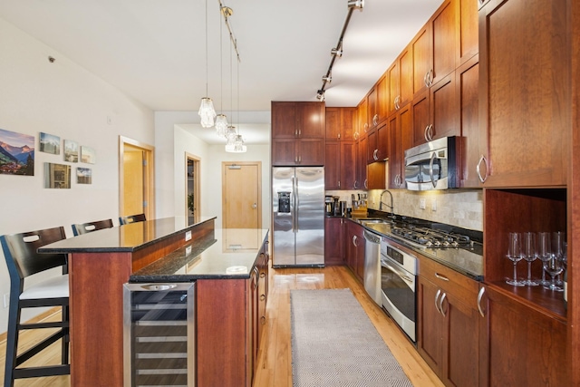 kitchen with tasteful backsplash, beverage cooler, a center island, stainless steel appliances, and a sink