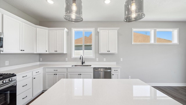 kitchen with stainless steel appliances, a sink, and light countertops