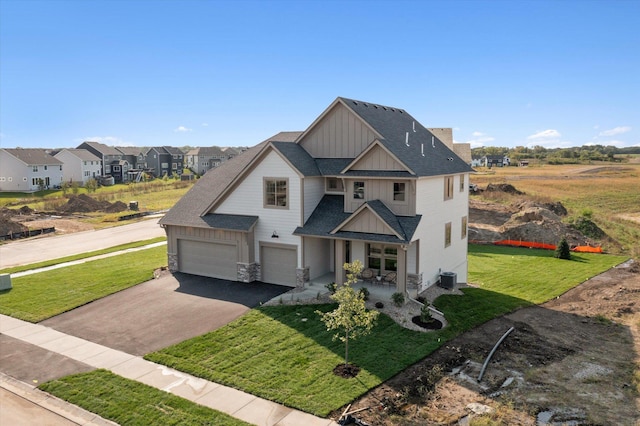 view of front of home featuring roof with shingles, board and batten siding, a front yard, a garage, and driveway