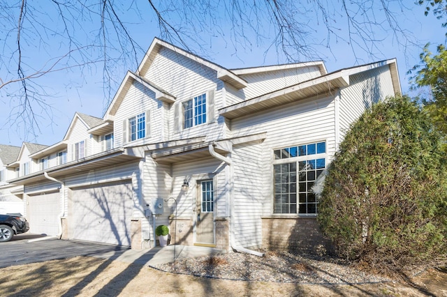 view of front of home with a garage, driveway, and brick siding