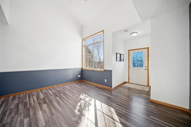 entrance foyer featuring vaulted ceiling, wood finished floors, and baseboards