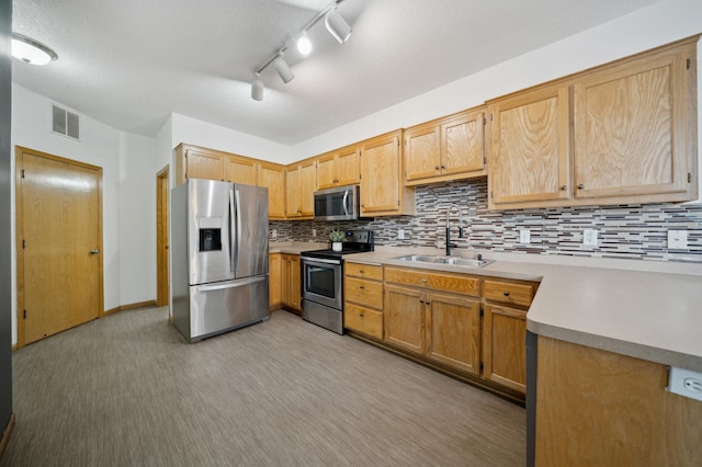 kitchen featuring visible vents, decorative backsplash, appliances with stainless steel finishes, light countertops, and a sink