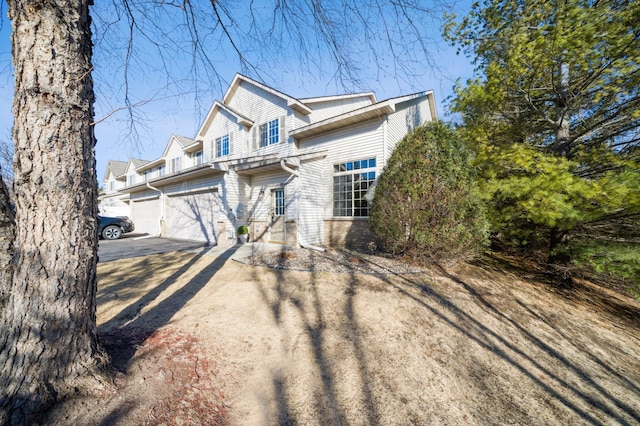 view of front of house with driveway, a garage, and brick siding