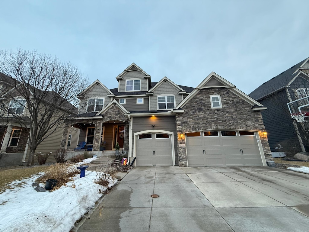 view of front facade with concrete driveway, a garage, and stone siding