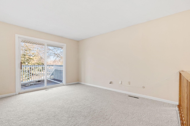 empty room featuring carpet flooring, visible vents, and baseboards