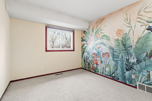 carpeted spare room with visible vents and baseboards