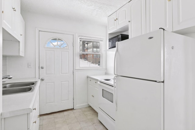 kitchen featuring a sink, white appliances, and white cabinetry