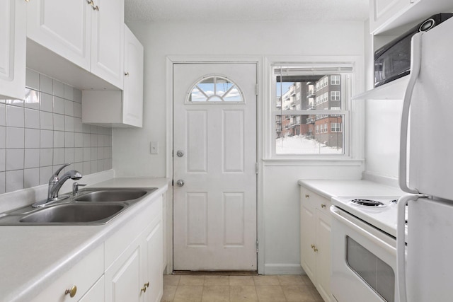 kitchen featuring a sink, white appliances, backsplash, and white cabinets