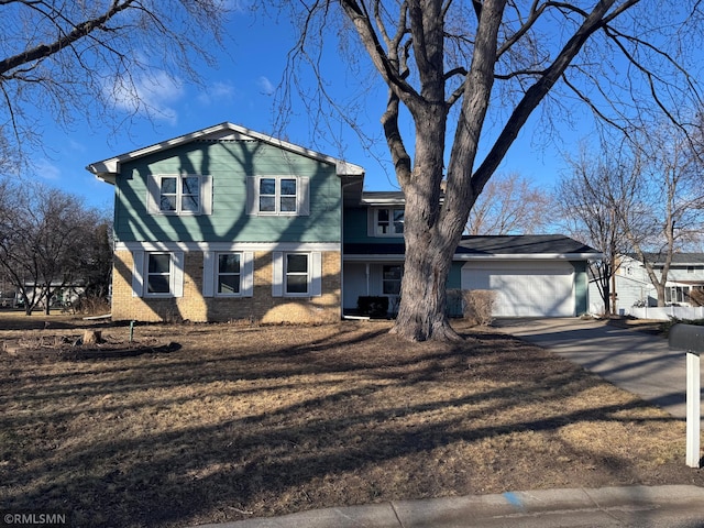 tri-level home with an attached garage, driveway, and brick siding