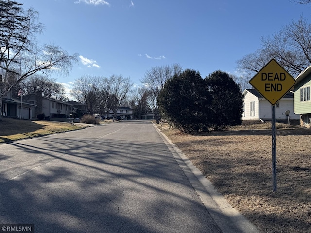 view of street with curbs, traffic signs, and a residential view