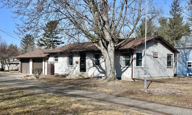 ranch-style house with aphalt driveway and an attached garage