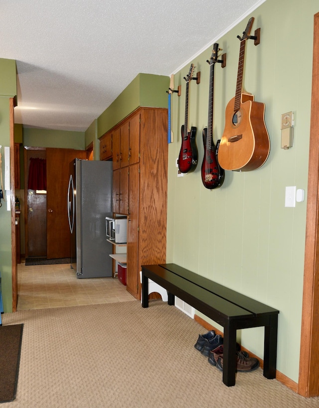 interior space featuring light carpet and a textured ceiling