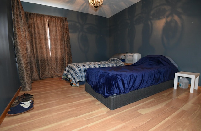 bedroom featuring baseboards and wood finished floors