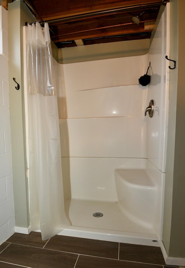 bathroom with wood finish floors and a shower stall