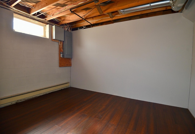 basement with electric panel, dark wood-type flooring, and baseboard heating