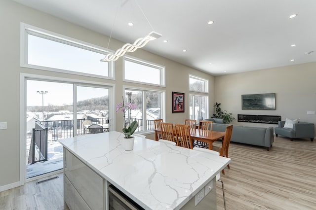 kitchen with light stone counters, plenty of natural light, and light wood-style flooring