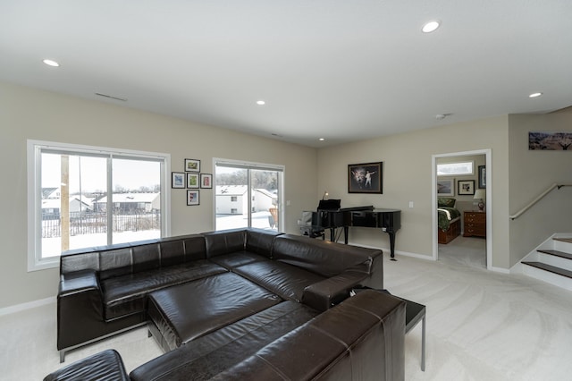 living room featuring recessed lighting, light colored carpet, baseboards, and stairs