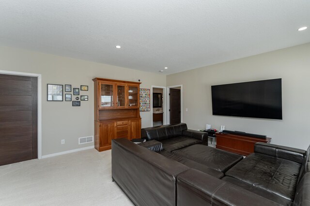 living area with recessed lighting, light colored carpet, visible vents, a textured ceiling, and baseboards