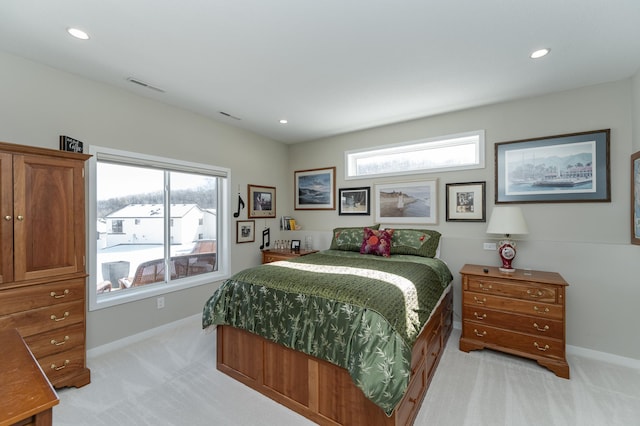 bedroom with light colored carpet, visible vents, baseboards, and multiple windows