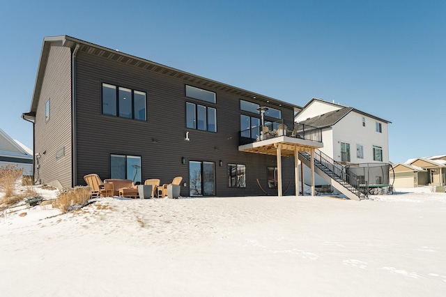 snow covered property with a deck and stairs