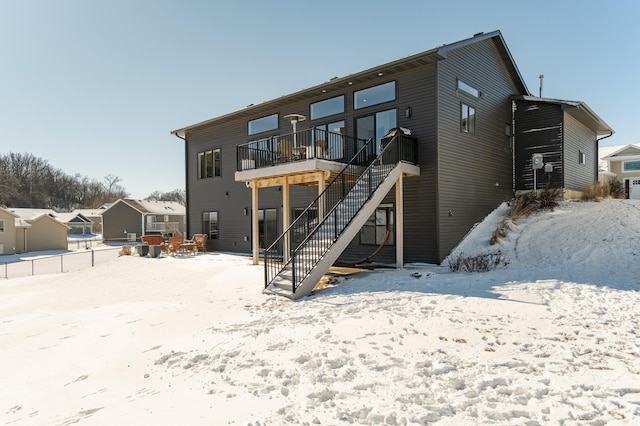 snow covered property featuring stairs