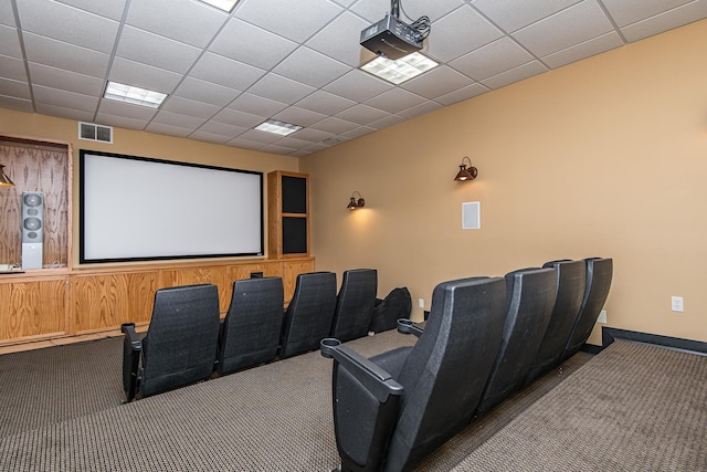 cinema room featuring carpet floors, a paneled ceiling, visible vents, and baseboards