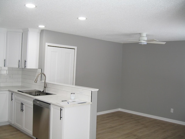 kitchen with dishwasher, backsplash, a sink, and light wood-style flooring