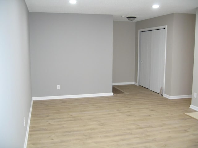 spare room with recessed lighting, light wood-style flooring, and baseboards