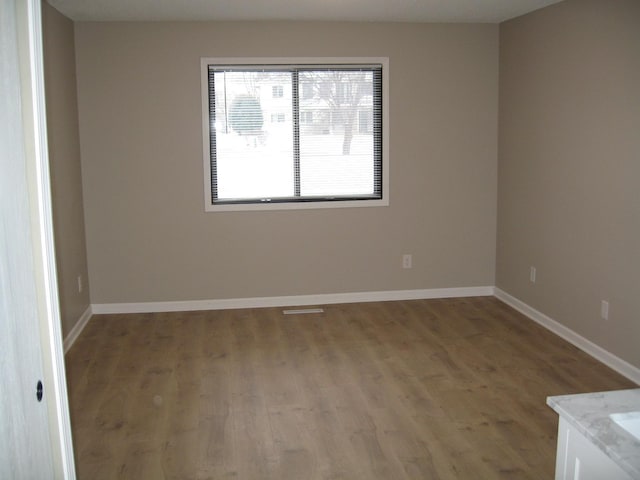 empty room with wood finished floors and baseboards