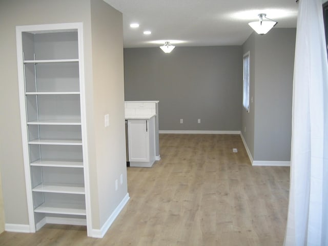 interior space featuring light wood-style floors, baseboards, and built in features