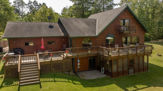 back of property featuring log veneer siding, roof with shingles, a yard, and a deck