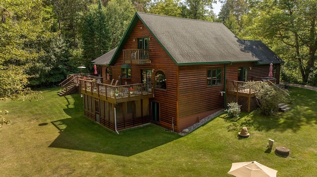 exterior space with faux log siding, roof with shingles, a yard, and a deck